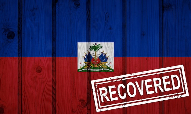 Flag of Haiti that survived or recovered from the infections of corona virus epidemic or coronavirus. Grunge flag with stamp Recovered