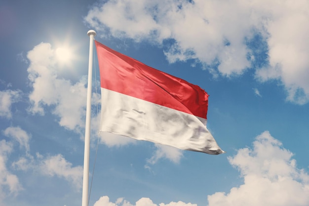 Flag of Indonesia, National symbol waving against cloudy, blue sky, sunny day