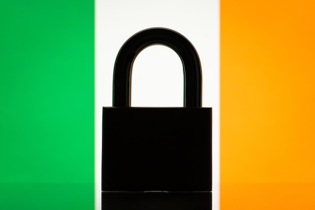 Flag of Ireland with closed lock on the foreground Concept of sanctions on Ireland embargo on some goods and services