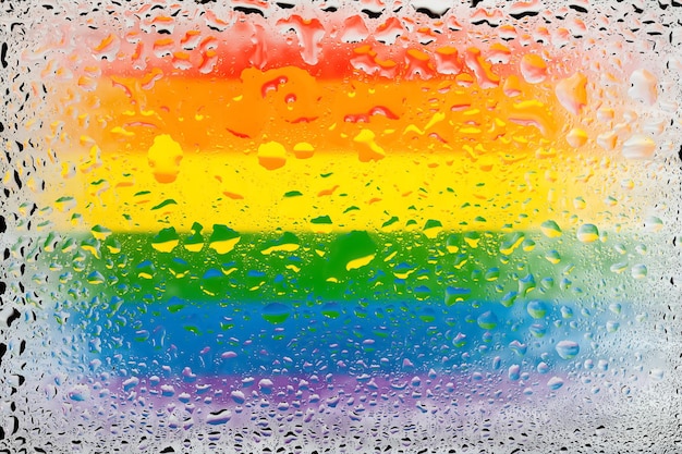 Flag of LGBT LGBTq flag on the background of water drops Flag with raindrops Splashes on glass