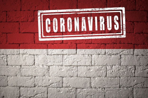 Flag of the Monaco with original proportions. stamped of Coronavirus. brick wall texture. Corona virus concept. On the verge of a COVID-19 or 2019-nCoV Pandemic.