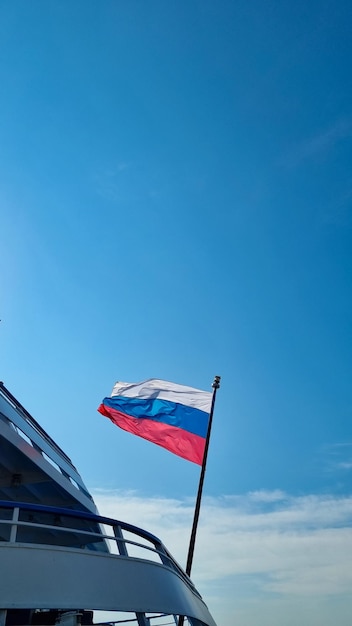 The flag of the Russian Federation against the background of a blue sky