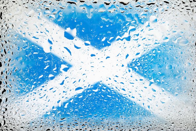 Flag of Scotland Scotland flag on background of water drops Flag with raindrops Splashes on glass