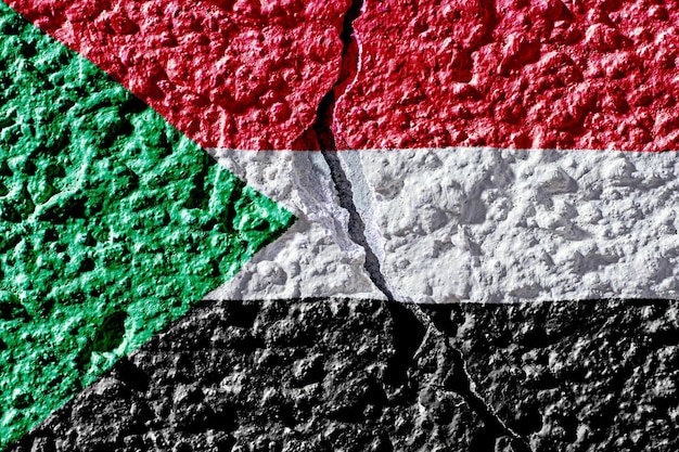 Flag of sudan on the background of a plastered wall with a crack military insurgency and civil war i