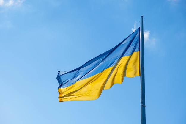 Flag of Ukraine flutters in blue sunny sky Large yellow blue Ukrainian national state flag War