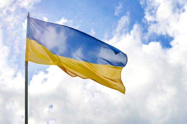 Flag of Ukraine in front of cloudy and sunny blue sky