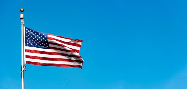 Flag of the USA against blue sky long panoramic picture with space for text