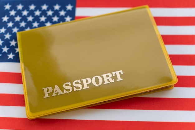 Flag of USA with passport Travel visa and citizenship concept residence permit in the country a yellow document with the inscription passport is on flag Close up top view