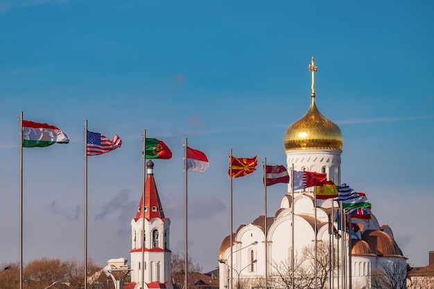 Flags of different countries on the background of the Orthodox Church