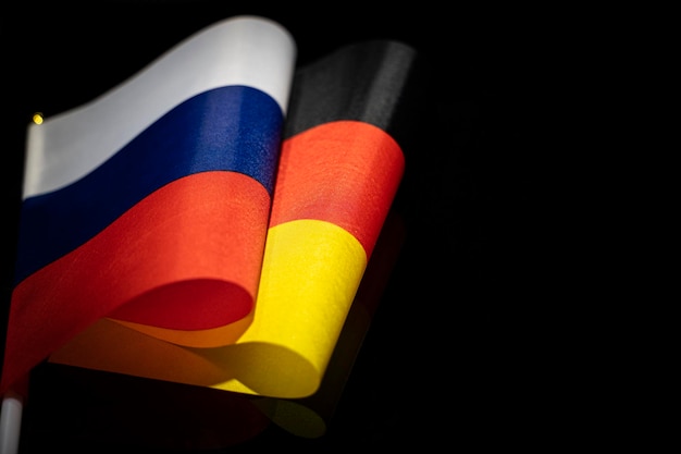 Flags of the Germany and russia on a black background The concept of interaction or counteraction between the two countries International relations political negotiations copy space