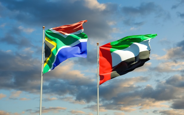 Flags of South Africa and UAE Arab Emirates on blue sky. 3D artwork