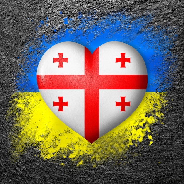 Flags of Ukraine and Georgia Flag heart on the background of the flag of Ukraine painted on a stone