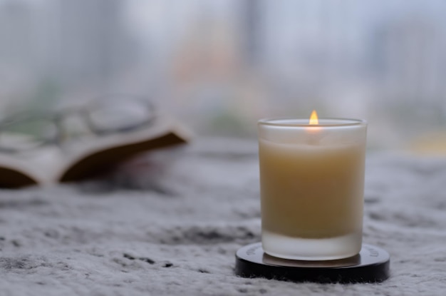 Flame burning at aroma candle for relaxing when reading book in winter season zen and relax