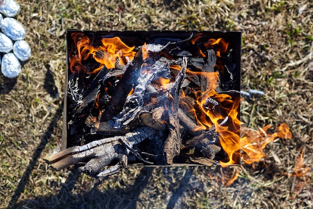 Flame. Old rusty metal brazier with burning wood and coals