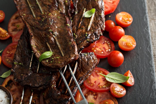 Flank steak on skewers with tomatoes