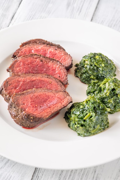 Flank steak with creamy spinach on the plate