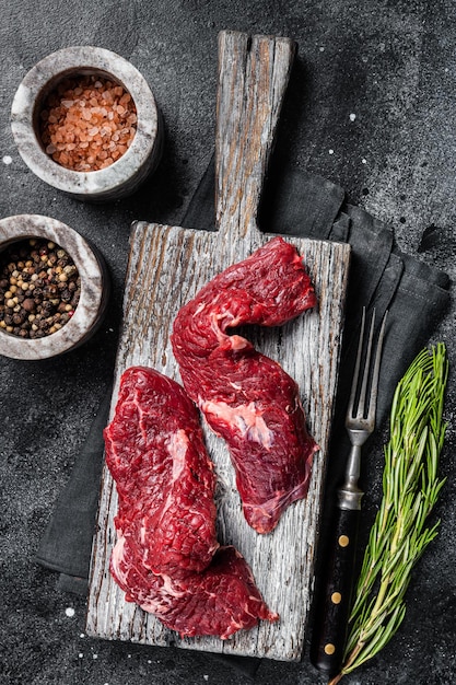 Flap steak flank raw cut and Machete skirt steak on wooden board Black background Top view