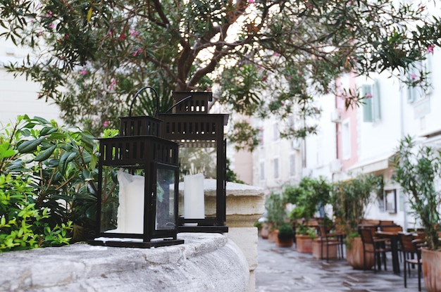 flashlight candlestick, black vintage decorative lanterns, candles stands outdoor in city. Garden