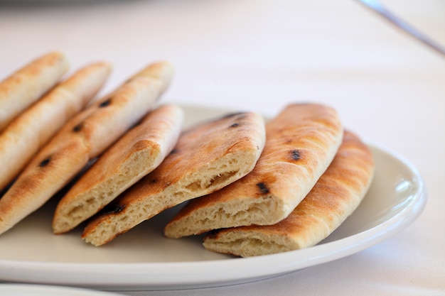 Flat bread cake cut into pieces on a plate.