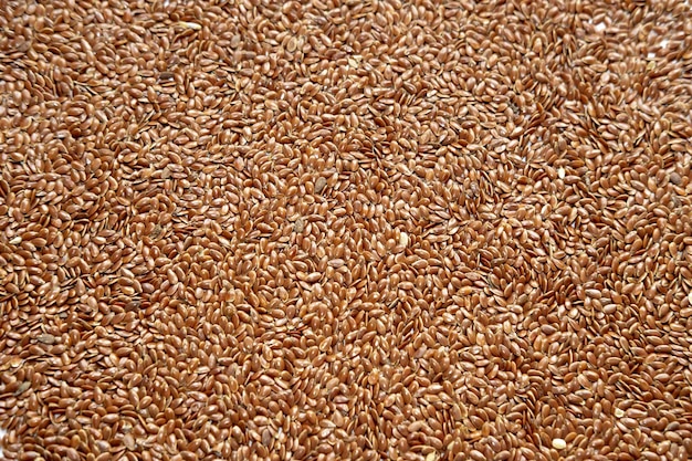 Flat even background of raw dry brown flax seeds