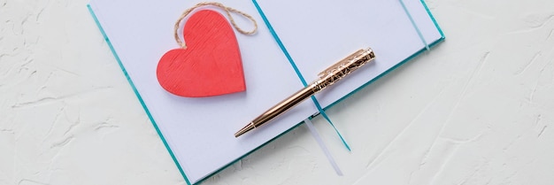 Flat lay arrangement of empty notebook journal with pen.Valentine's day concept, love of nature