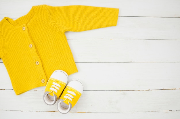 Flat lay baby clothes with wooden background