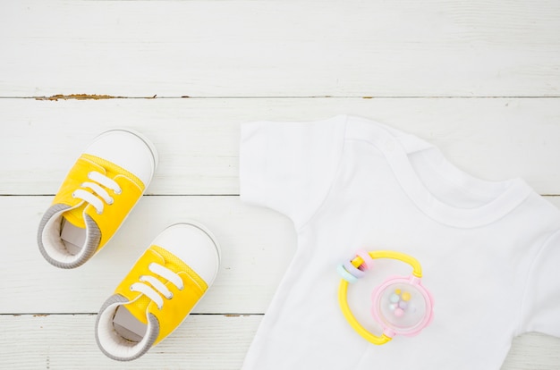 Flat lay baby clothes with wooden background