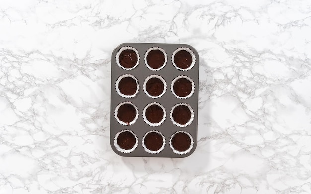 Flat lay. Baking chocolate cupcakes. Scooping chocolate cupcake batter into a cupcake pan.