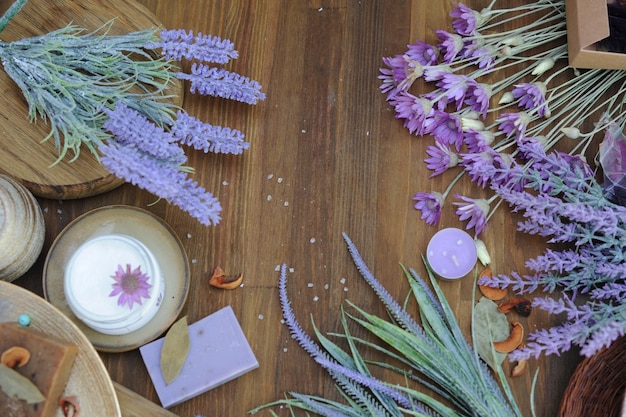 Flat lay bath cosmetics cream and lavender soap spa template at wooden background with lavender flowers