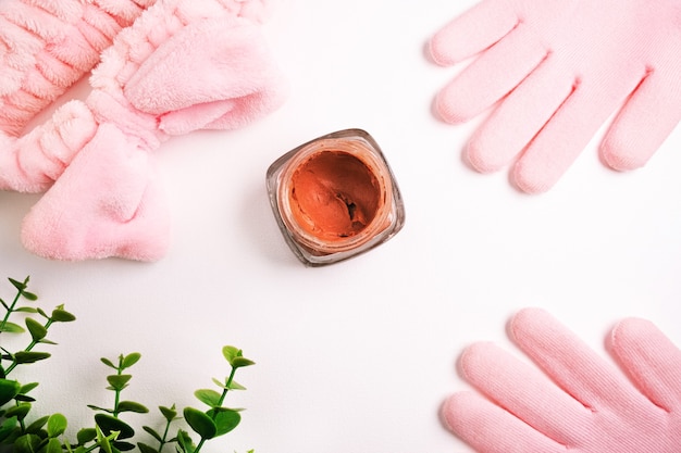 Flat lay of beauty care products, coral or pink clay for face and body surrounded by beauty accessories