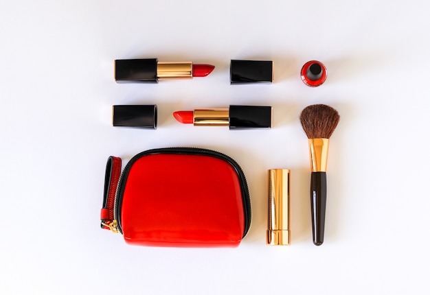 Flat lay of beauty cosmetic products in red, black and gold color knolled 