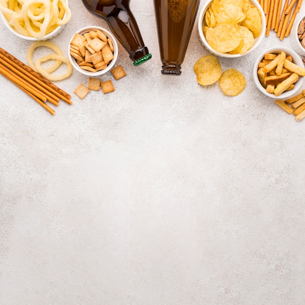 Flat lay beer bottles and snacks frame