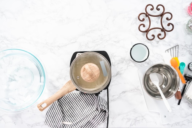 Flat lay. Caramelizing sugar in saucepan to make homemade lollipops.