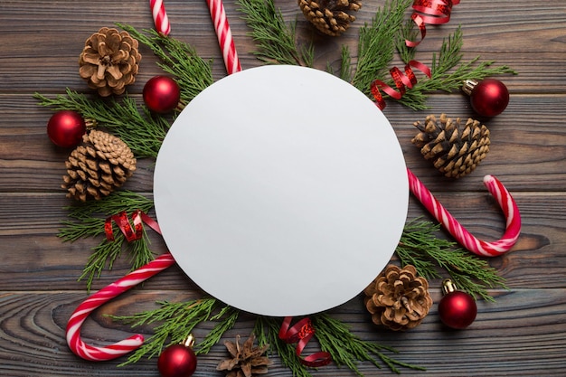 Flat lay Christmas composition Round Paper blank pine tree branches christmas decorations on Colored background Top view copy space for text