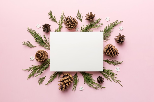 Flat lay Christmas composition square Paper blank pine tree branches christmas decorations on Colored background Top view copy space for text