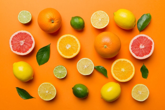 Flat lay of citrus fruits like lime orange and lemon with lemon tree leaves on light colored background Space for text healthy concept Top view