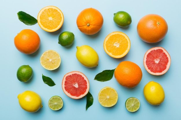 Flat lay of citrus fruits like lime orange and lemon with lemon tree leaves on light colored background Space for text healthy concept Top view