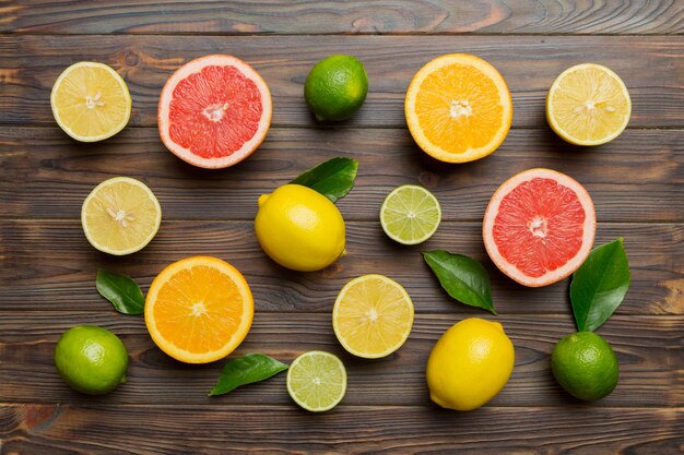 Flat lay of citrus fruits like lime orange and lemon with lemon tree leaves on light colored background Space for text healthy concept Top view