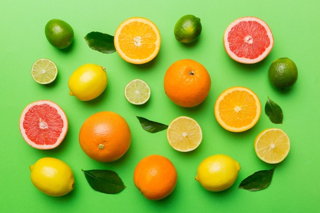 Flat lay of citrus fruits like lime orange and lemon with lemon tree leaves on light colored background Space for text healthy concept Top view