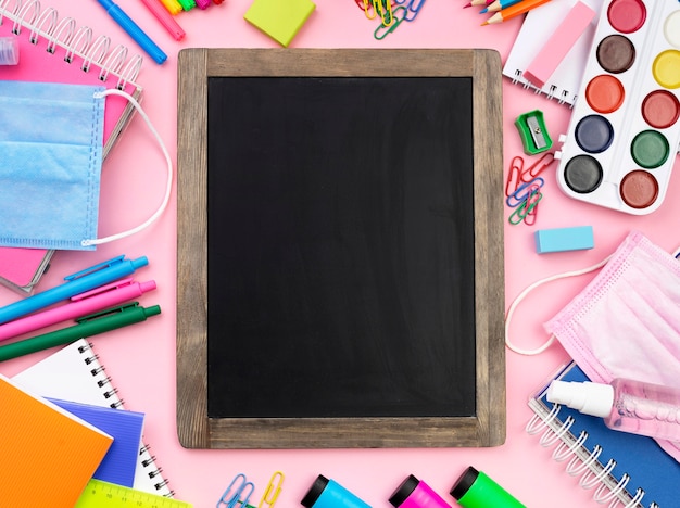 Flat lay of colorful back to school stationery with blackboard