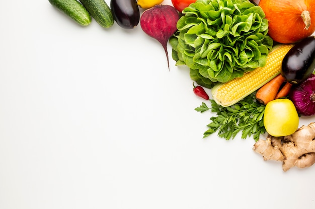 Flat lay colourful veggies on white background with copy space