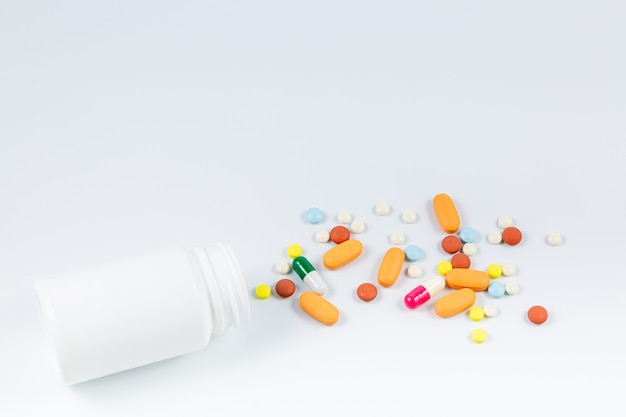 Flat lay composition with bunch of different colorful pills scattered on table from popped