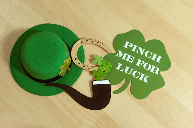 Flat lay composition with clover leaves green hat and horseshoe on wooden background St Patrick39s day