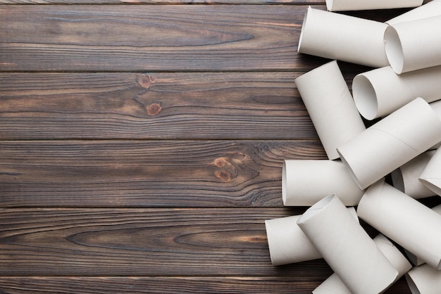 Flat lay composition with empty toilet paper rolls and space for text on color background Recyclable paper tube with metal plug end made of kraft paper or cardboard