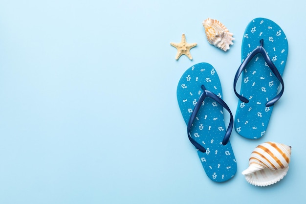 Flat lay composition with flip flops and seashell on colored background Space for text top view