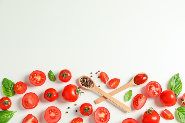 Flat lay composition with fresh tomatoes, pepper, basil and wooden spoons space for text. Ripe vegetables