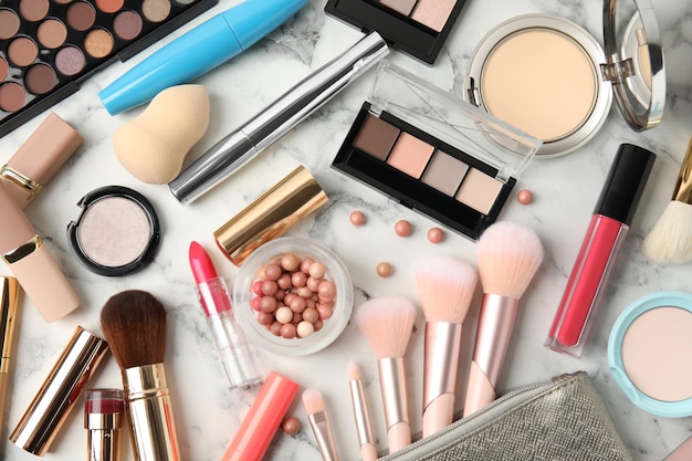 Flat lay composition with makeup products on white marble table