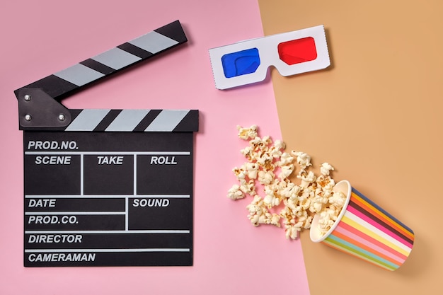 Flat lay composition with popcorn, 3d glasses and clapper board on color surface