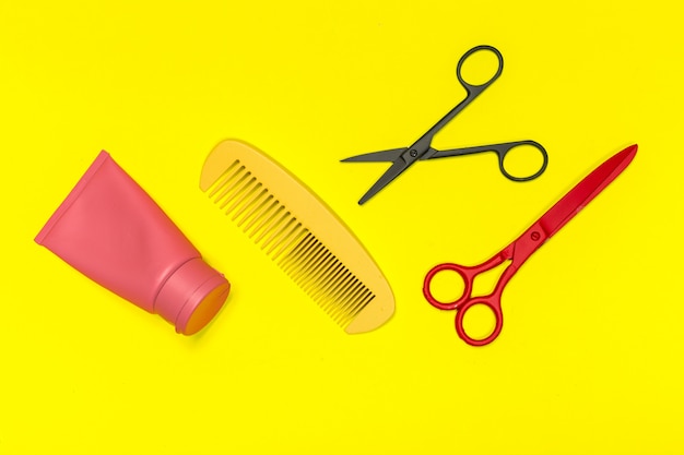 Photo flat lay composition with professional hairdresser tools on yellowbackground