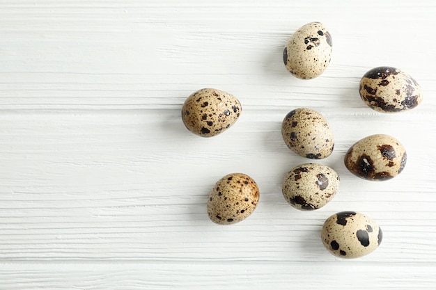 Flat lay composition with quail eggs on white wooden